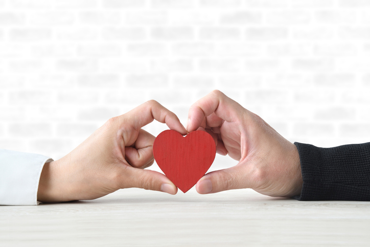 Couple holding heart object together