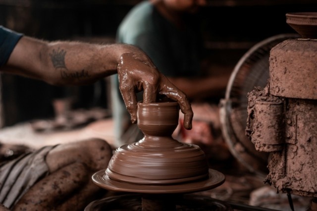 a man is making a vase out of clay