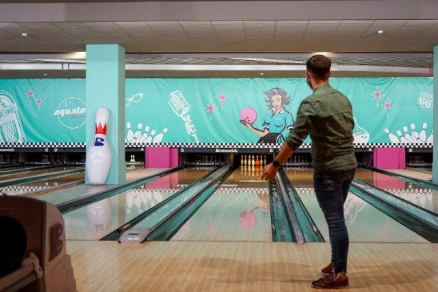 a man standing in front of a bowling alley