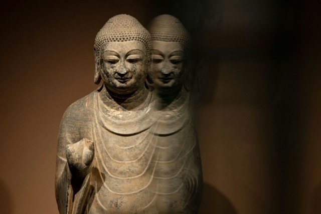 A stone buddha statue with shadow.